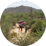 Family_Trail_C180 A red truck is parked on the side of a dirt road.
