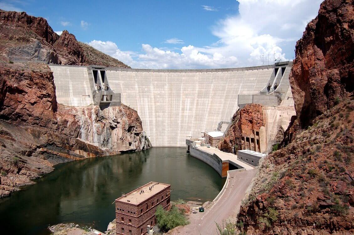 A large dam with water coming out of it.